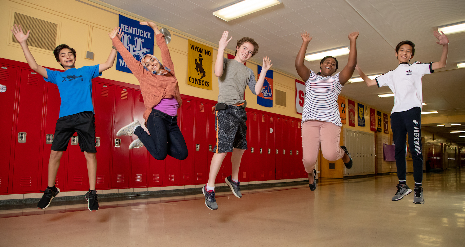 Students jumping with joy in hallway